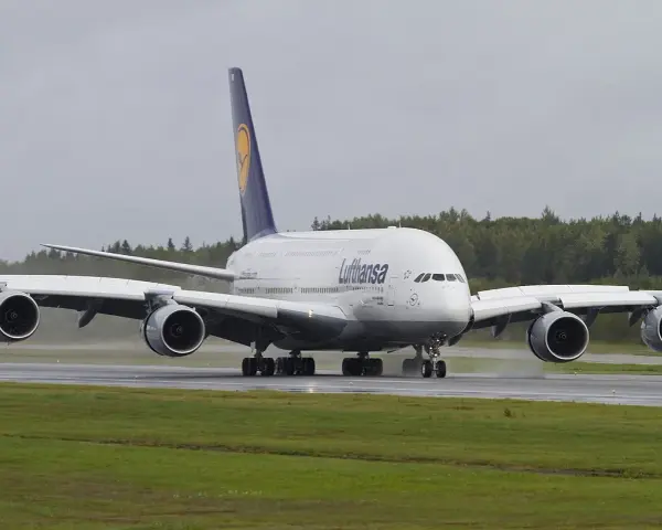 Lufthansa A380, największy samolot pasażerski, kołuje po mokrym pasie startowym.