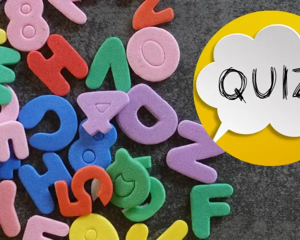 Kolorowe piankowe litery i cyfry, obok dymku z napisem "QUIZ!".