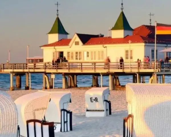 Plaża w Ahlbecku z molo i charakterystycznymi koszami plażowymi. Idealne miejsce na relaks i podziwianie zachodu słońca.