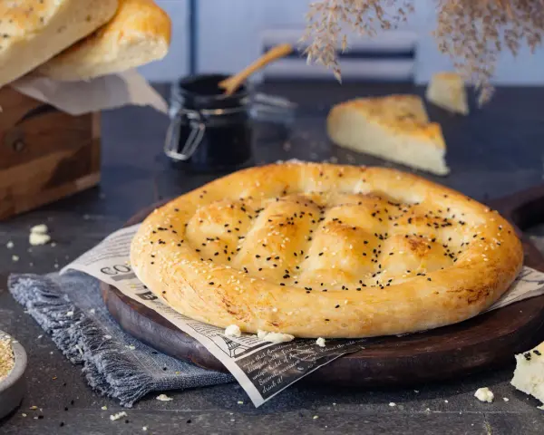 Frisch gebackenes Fladenbrot mit Sesam und Schwarzkümmel, bereit zum Genießen. Selbst Fladenbrot backen ist eine Freude!