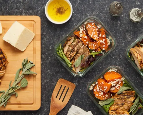 Repas préparés pour manger healthy : poulet grillé, patates douces, fromage et salade.