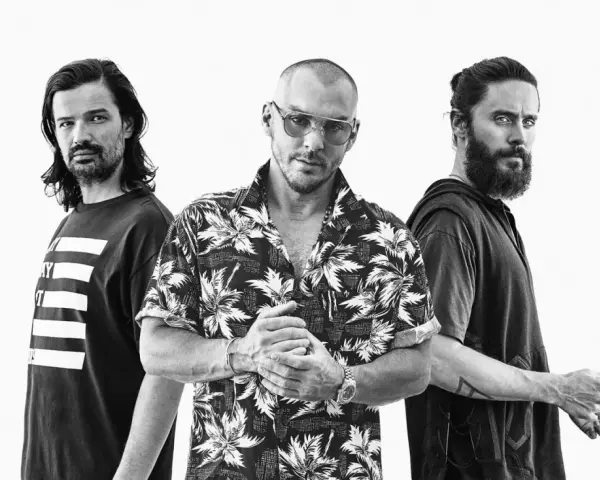 Les membres de Thirty Seconds to Mars posent ensemble, un regard intense sur le visage de Jared Leto.
