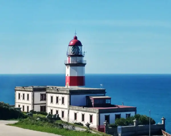 Faro blanco y rojo en la costa, un punto de referencia en la ruta de Vigo a Baiona.