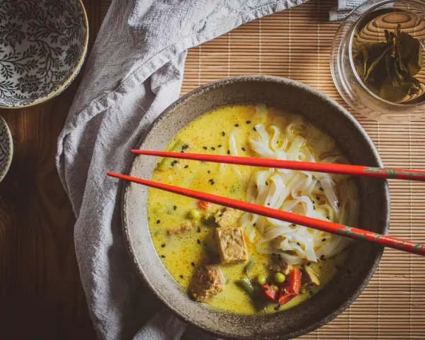 Aksamitna zupa laksa z makaronem ryżowym, tofu i warzywami. Idealny przepis na rozgrzewający posiłek.