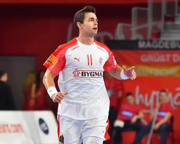 Piłkarz ręczny Rasmus Lauge Schmidt w białej koszulce z czerwonymi rękawami i numerem 11.