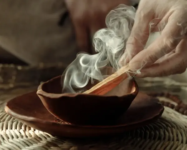 Dym z kadzidła palo santo unosi się z glinianej miseczki. Poznaj, jak palić palo santo, by oczyścić przestrzeń.