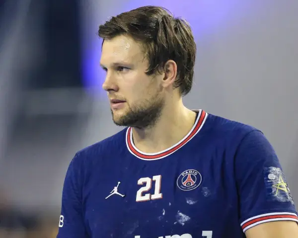 Piłkarz ręczny PSG z numerem 21 na koszulce, skupiony na grze.