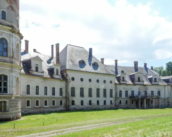 Dawny pałac bożków, zniszczony i opuszczony, z charakterystycznymi okrągłymi oknami i wieżą.
