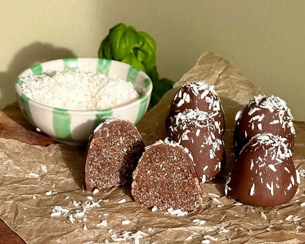 Chokladbollar recept: Mörka, kokosdränkta godsaker med en skål riven kokos i bakgrunden. Perfekt för fikat!