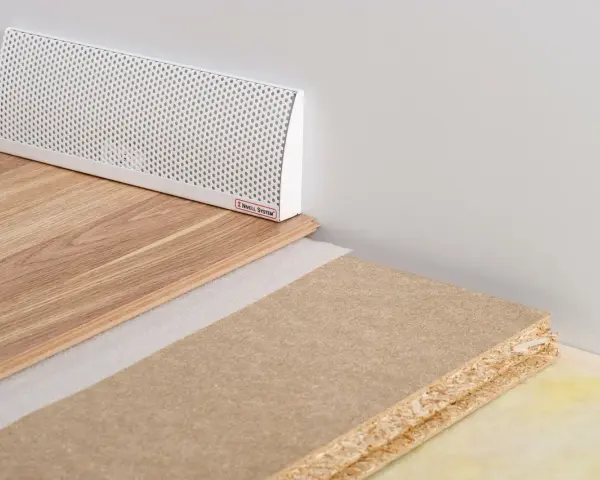 En vit ventilationslist för ett passivt ventilerat golv, med trägolv och byggmaterial.