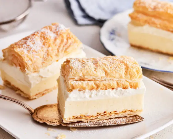 Zarte Cremeschnitten, die nach dem original cremeschnitten rezept zubereitet wurden, bestäubt mit Puderzucker.