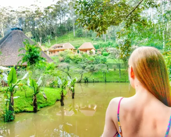 Widok na malowniczy krajobraz z jeziorem i domkami w stylu madagaskarskim. Atrakcje przyrodnicze i architektoniczne zachwycają.