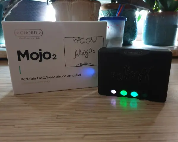 Zestaw Chord Mojo 2: pudełko i czarny wzmacniacz z podświetlanymi przyciskami.