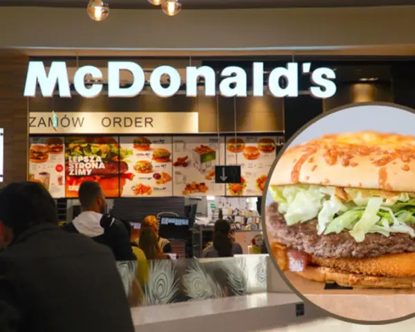 Zbliżenie na burgera McDonald's na tle wnętrza restauracji z menu.