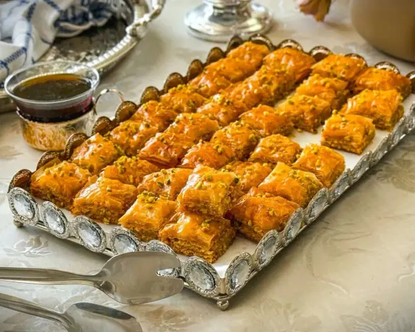 Ein Tablett voller goldbrauner Baklava, bestreut mit Pistazien. Dieses köstliche Baklava-Rezept ist perfekt für jede Feier.