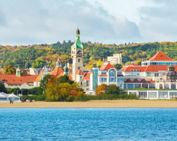 Malownicze budynki i plaża w Sopocie, idealne miejsce, by zobaczyć w Sopocie. W tle jesienne drzewa.
