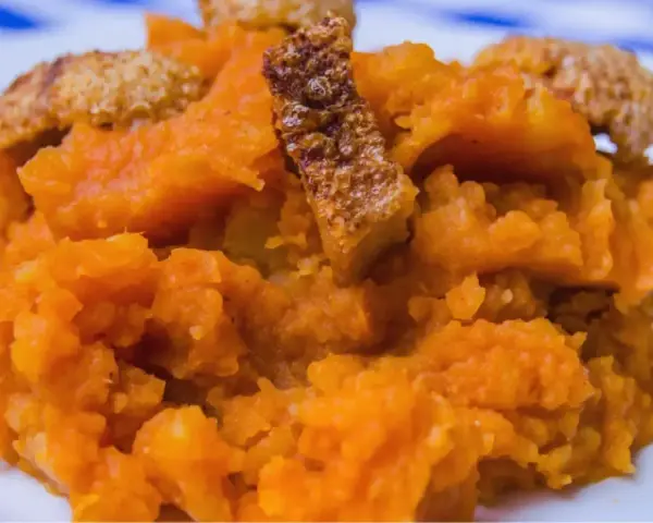 Patatas revolconas cremosas con trozos crujientes de torreznos, un plato tradicional español.