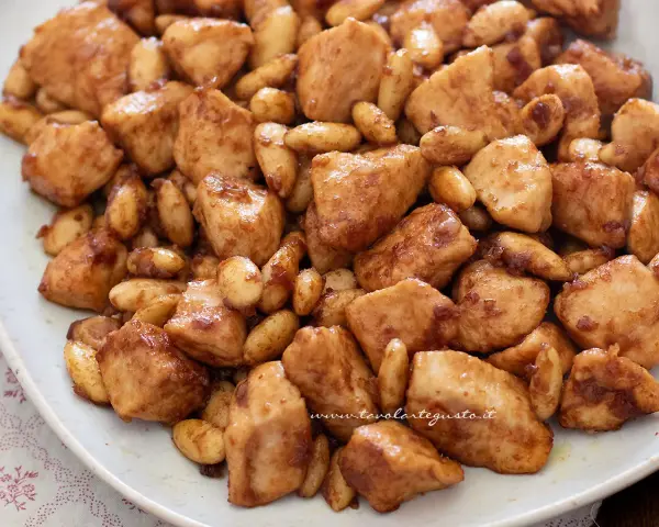 Un invitante piatto di pollo alle mandorle, con bocconcini dorati e mandorle tostate immerse in una salsa lucida.