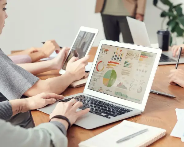 Analityk finansowy pracuje nad raportem na laptopie, analizując wykresy i dane.