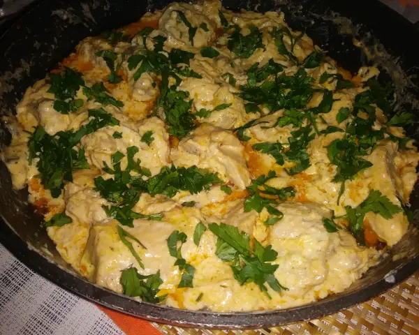 Keto kurczak z mascarpone w kremowym sosie, posypany świeżą natką pietruszki. Pyszne danie gotowe do podania.