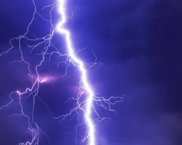 Potężne wyładowanie atmosferyczne rozświetla nocne niebo. Burza może oznaczać problemy, ale pamiętaj o możliwości uzyskania odszkodowanie za brak prądu.