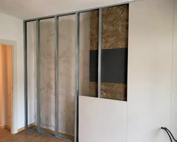 Costruzione di una parete interna con struttura metallica, isolamento acustico e pannelli in cartongesso. Si valuta lo spessore per un ottimo isolamento acustico delle pareti.