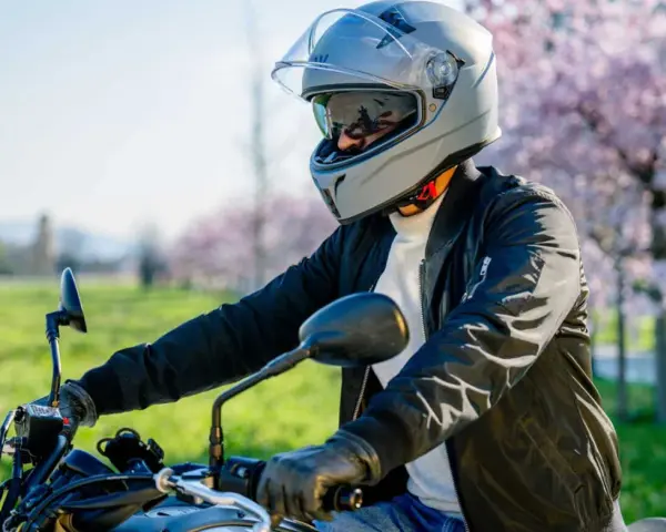 Motociclista con casco grigio, pronto per un giro. La misura testa è perfetta per la sicurezza.
