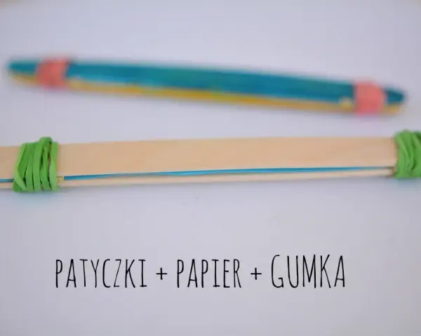 Proste instrumenty muzyczne do zrobienia: patyczki, papier i gumka. Dwa patyczki połączone gumkami, jeden z kolorowym papierem w środku.