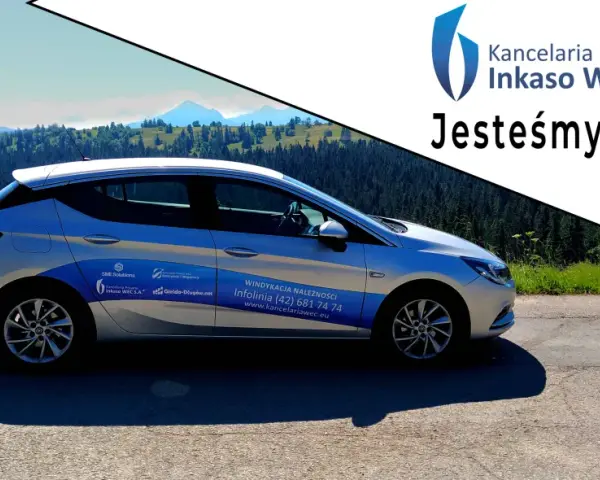 Srebrny samochód Kancelarii Prawnej Inkaso WEC S.A. z napisem "Jesteśmy w terenie!" na tle górskiego krajobrazu.