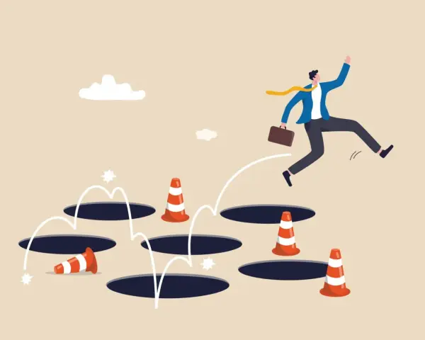 Un homme d'affaires saute par-dessus des trous, naviguant dans un parcours semé d'embûches. Il semble éviter les obstacles, comme dans un remembrement de propriété complexe.