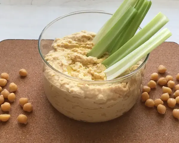 Pyszny, kremowy hummus z ciecierzycy, idealny do maczania łodyg selera. Oto co to jest hummus – zdrowa przekąska!