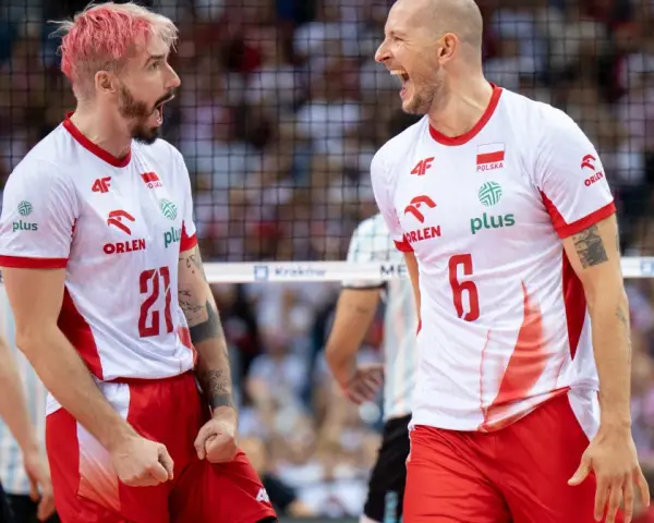 Dwóch zawodników siatkówka polska w biało-czerwonych strojach świętuje punkt. Jeden z różowymi włosami, drugi łysy, obaj krzyczą z radości.