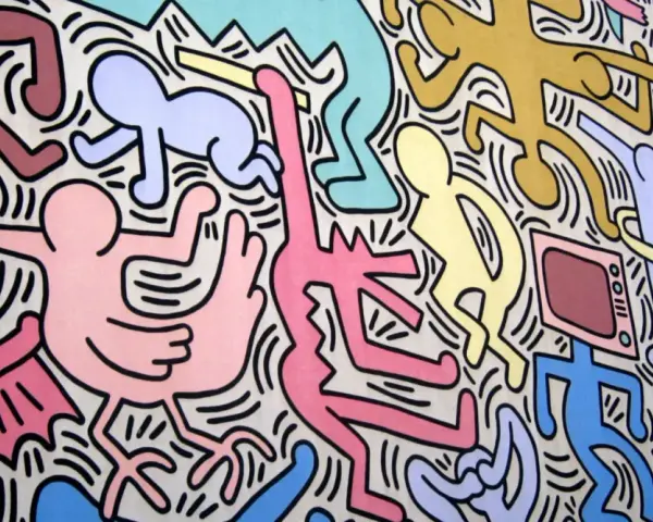 Une fresque colorée de Keith Haring, œuvre la plus connue, avec des figures stylisées dansant et interagissant, un chien jaune, un bébé et une télévision.