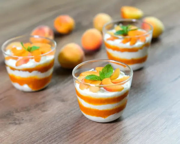 Cremige Desserts mit Aprikosenmus und Sahne, garniert mit frischen Aprikosenstücken und Minze. Eine köstliche Alternative zu shaved ice.
