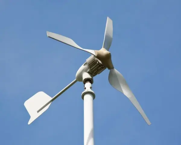 Biała elektrownia wiatrowa z trzema łopatami na tle błękitnego nieba.