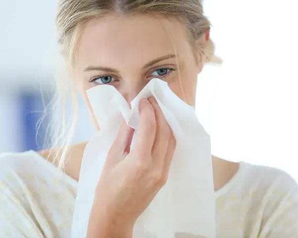 Donna con fazzoletto nasale, forse soffre di allergia aria condizionata.