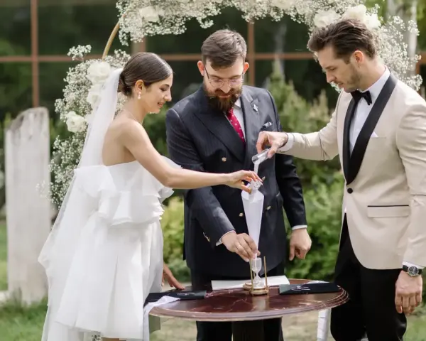 Para młoda podczas ceremonii, w tle łuk weselny. Zastanawiasz się nad wedding planner cena?