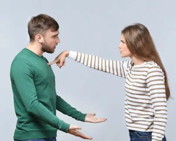 Une femme pointe du doigt un homme, exprimant son mécontentement. Ce geste symbolise les choses à ne pas accepter en couple, comme le manque de respect ou la communication agressive.