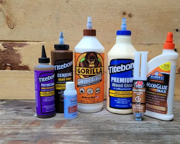A collection of wood glues, including Gorilla Wood Glue and Titebond, are displayed. The question of what is the strongest adhesive glue is posed.