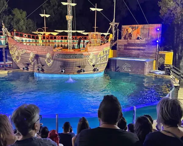 A pirate ship show at Zoomarine Roma with performers on a stage and in the water.