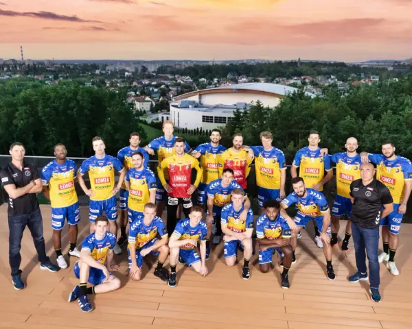 Drużyna piłkarzy ręcznych Vive Kielce pozuje do zdjęcia na tle panoramy miasta.