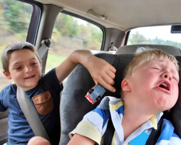 Un enfant pleure dans la voiture, son frère joue avec une petite voiture. Le temps de conduite chauffeur de bus est long pour certains.