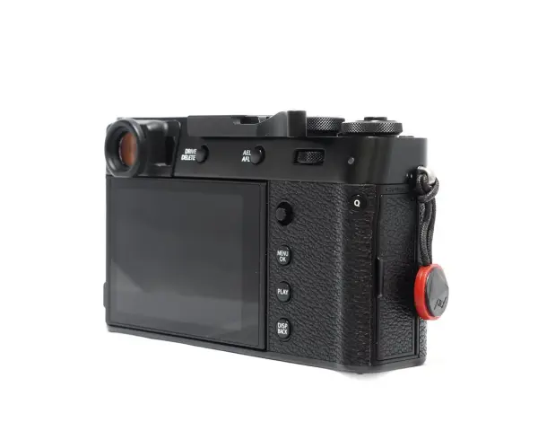 Czarne body aparatu Fujifilm X100S z widocznym ekranem, przyciskami i uchwytem na pasek.