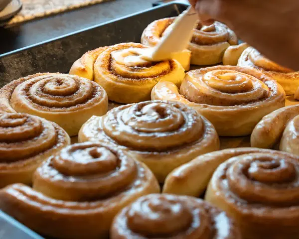 Saftige Zimtschnecken werden mit Glasur überzogen. Ein köstliches Zimtschnecken Rezept, das jeden begeistert.
