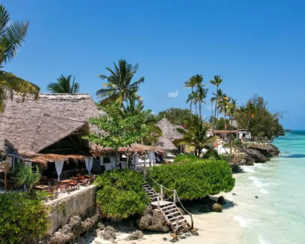 Zanzibar w marcu: słoneczna pogoda, palmy, plaża i urokliwe bungalowy z krytymi strzechą dachami. Idealne miejsce na relaks.