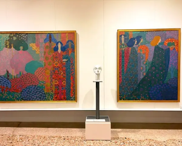 Due tele colorate con figure femminili e un busto bianco in un museo d'arte moderna a Venezia.