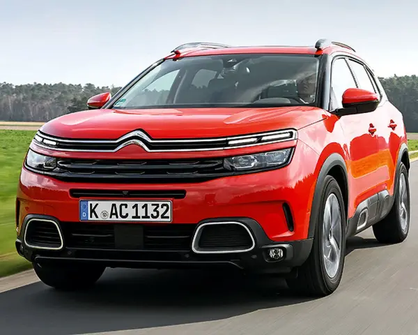 Roter Citroën C5 Aircross fährt auf einer Landstraße. Trotz seines modernen Designs gibt es Berichte über Citroën C5 Aircross Probleme.