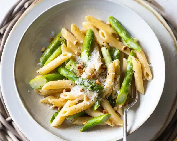 Penne-Nudeln mit frischem Spargel, Pinienkernen und Parmesan. Ein leichtes und frühlingshaftes Gericht, das Lust auf mehr macht.