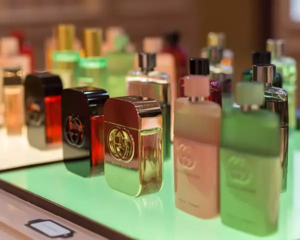 Butelki perfum Gucci Guilty na zielonym podświetlanym tle.