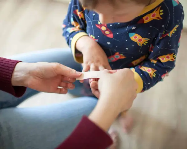 Un pansement appliqué sur un petit doigt, un remède grand-mère brûlure main réconfortant.